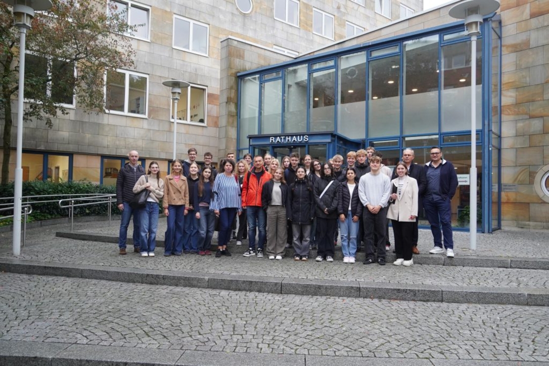 Eine Sch&uuml;lergruppe posiert mit Lehrern vorm Lingener Rathaus