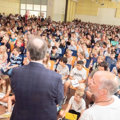 Blick auf eine voll besetzte Mensa w&auml;hrend der Begr&uuml;&szlig;ungsfeier f&uuml;r F&uuml;nftkl&auml;ssler.