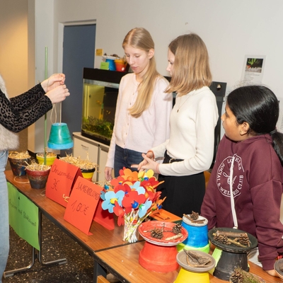 Kinder schauen sich an einer Mitmachstation Materialien und Modelle zu Natur und Umwelt an.