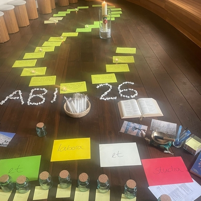 Auf dem Boden ausgelegte Karten und Materialien zur Abiturvorbereitung mit der Aufschrift Abi 2026.