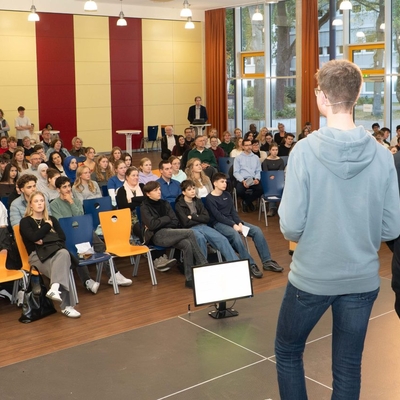 Blick von der B&uuml;hne auf das sitzende Publikum in einem Veranstaltungsraum.