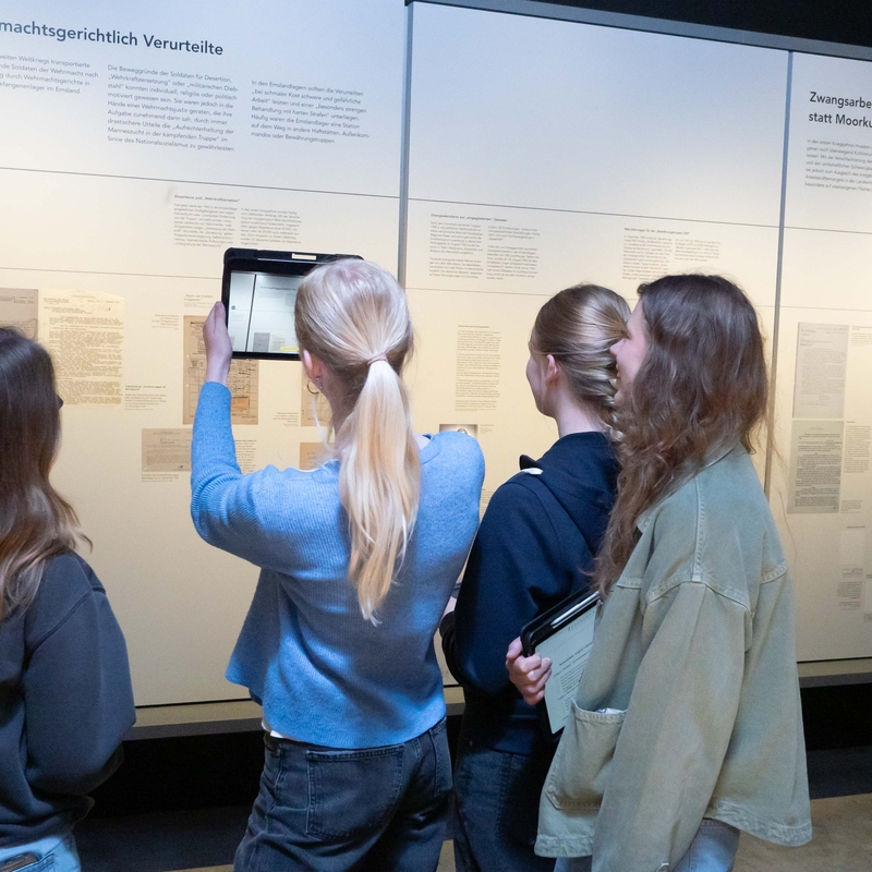 Sch&uuml;lerinnen mit Tablets erkunden ein Museum