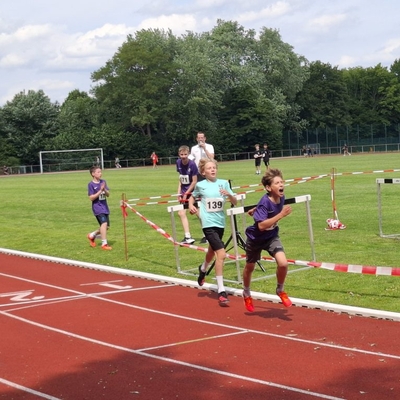 Jugendliche laufen bei einem Leichtathletikwettkampf auf der Tartanbahn.