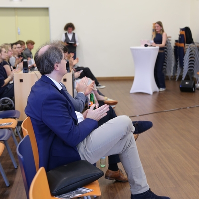 Blick aus dem Publikum auf eine Pr&auml;sentation in einem Veranstaltungsraum.