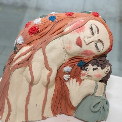 Skulptur einer Frau mit Kind in warmen Farbt&ouml;nen.