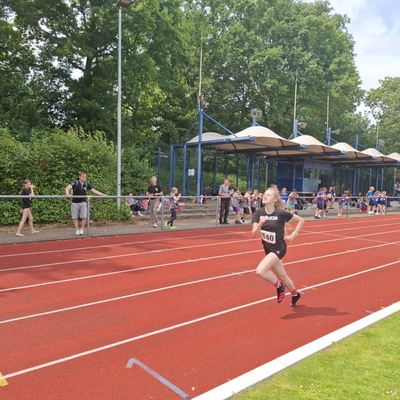 Ein Jugendlicher l&auml;uft allein auf einer roten Tartanbahn.