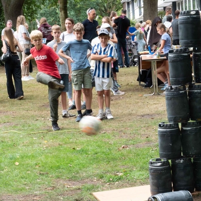 Kinder spielen im Freien ein Ballspiel auf einer Wiese.