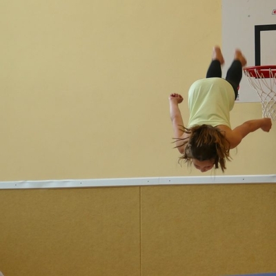 Eine Person zeigt eine akrobatische &Uuml;bung in einem Innenraum.