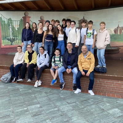 Gruppe von Jugendlichen posiert gemeinsam vor einer bemalten Wand.