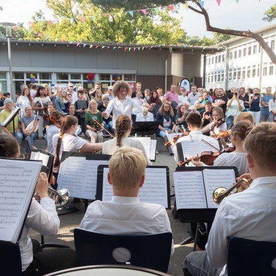 Musikerinnen und Musiker spielen im Freien vor Publikum.