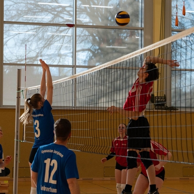 Ein Jugendlicher schl&auml;gt den Ball bei einem Volleyballspiel in der Halle.