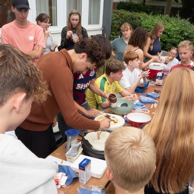 Jugendliche stehen an einem Cr&ecirc;pes-Stand auf dem Schulhof.