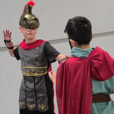 Zwei Sch&uuml;ler in r&ouml;mischen Kost&uuml;men stellen eine Szene nach.