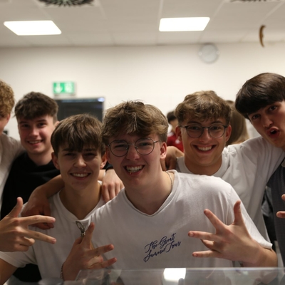 Gruppe von Jugendlichen posiert lachend f&uuml;r ein Foto.