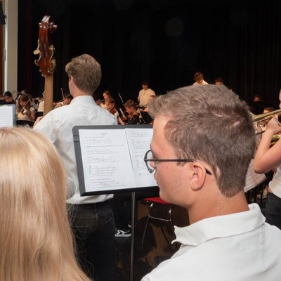 Musikerinnen und Musiker spielen vor Publikum in einem Veranstaltungsraum.