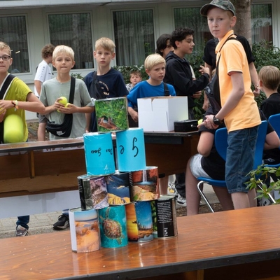 Jugendliche beim Dosenwerfen.