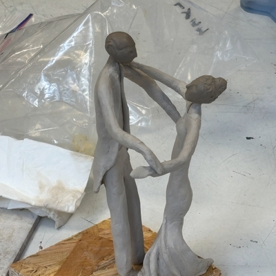 Zwei abstrahierte Figuren aus Ton stehen sich gegen&uuml;ber.