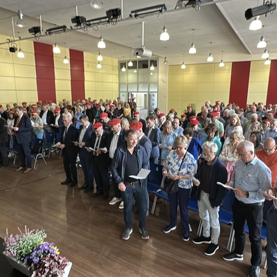 Viele G&auml;ste stehen bei einer Veranstaltung in der Mensa beisammen.