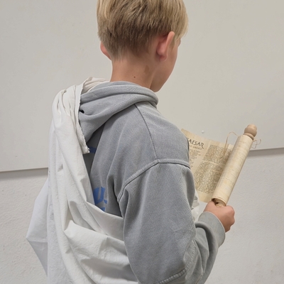 Ein Sch&uuml;ler betrachtet ein Blatt oder Schriftst&uuml;ck im Unterricht.