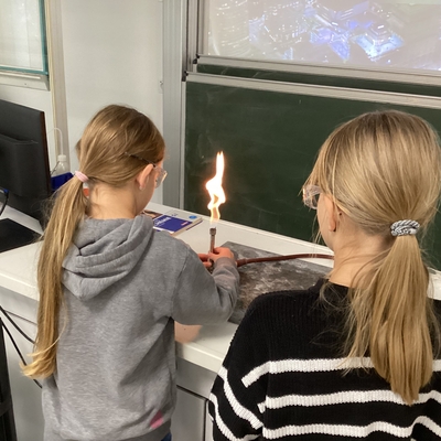 Zwei Sch&uuml;lerinnen arbeiten mit einem Bunsenbrenner im Chemieunterricht.
