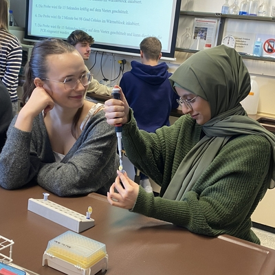 Zwei Sch&uuml;lerinnen arbeiten gemeinsam an einem Versuch mit Pipette.