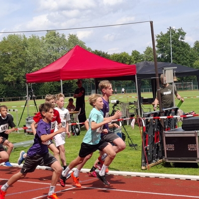 Mehrere Jugendliche sprinten bei einem Wettkampf auf einer Laufbahn.