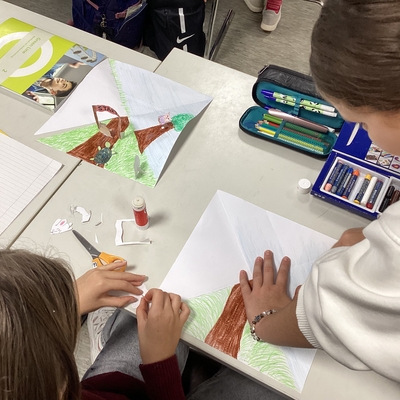 Sch&uuml;lerh&auml;nde arbeiten mit Papier, Stiften und Bastelmaterial.