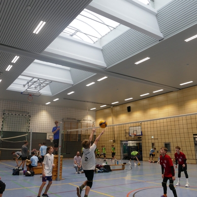 Spielszene eines Volleyballspiels in einer Sporthalle.
