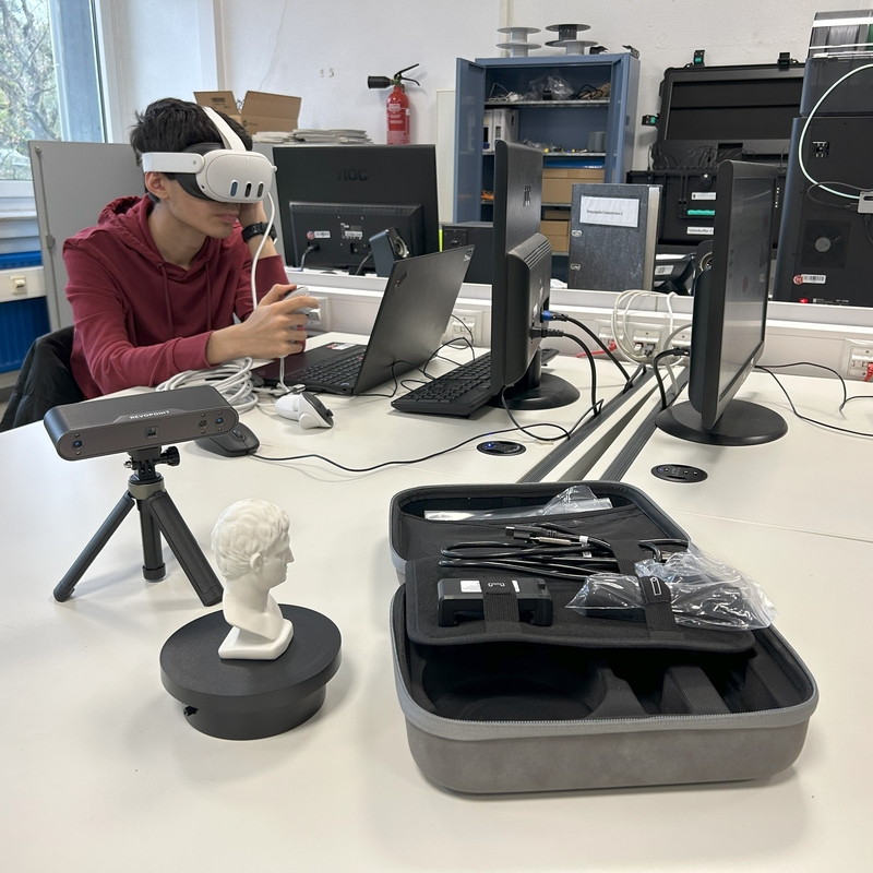 Sch&uuml;ler sitzt mit VR-Brille vor einem Laptop.
