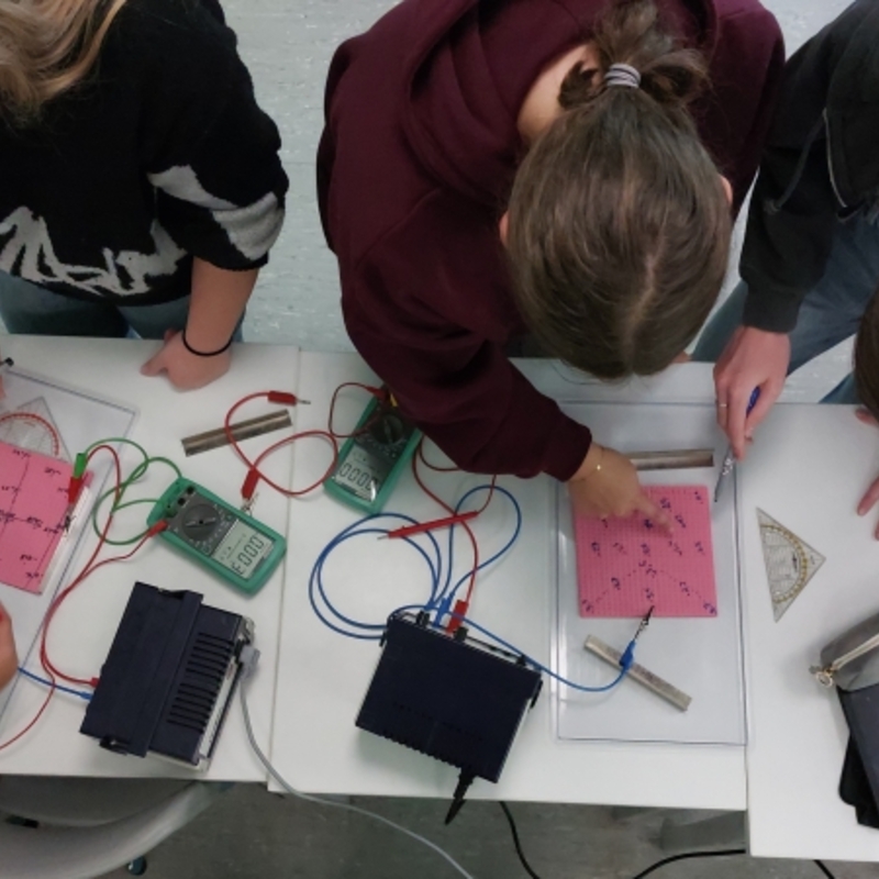 Sch&uuml;lerinnen und Sch&uuml;ler bei der Durchf&uuml;hrung eines Versuchs im Fach Physik.