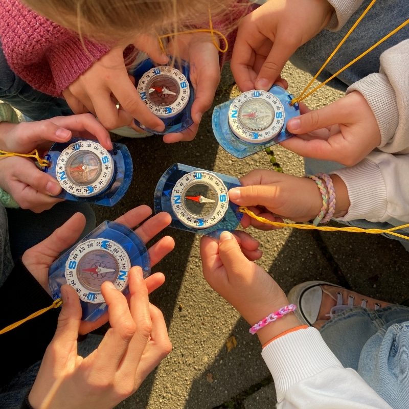 Sch&uuml;lerh&auml;nde halten Kompasse