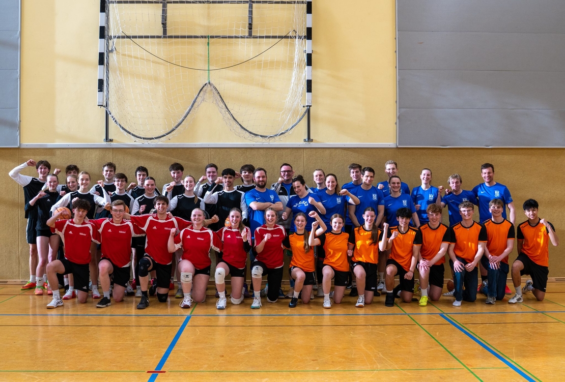 Gruppenfoto von Sch&uuml;lerinnen, Sch&uuml;lern und Lehrkr&auml;ften in einer Sporthalle nach einem sportlichen Wettkampf.