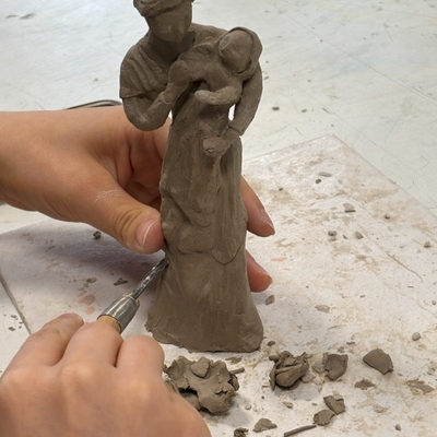 H&auml;nde formen eine Tonfigur auf einem Arbeitstisch.