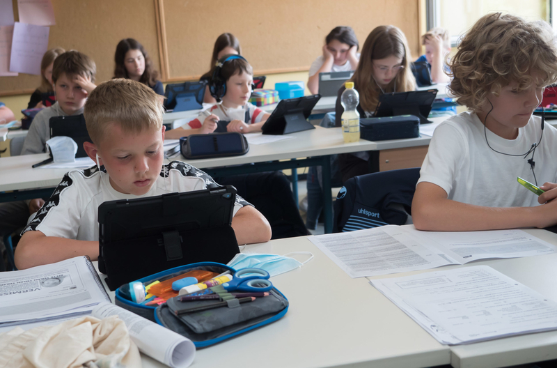 Sch&uuml;lerinnen und Sch&uuml;ler arbeiten mit Tablet-PCs in einem Klassenzimmer.