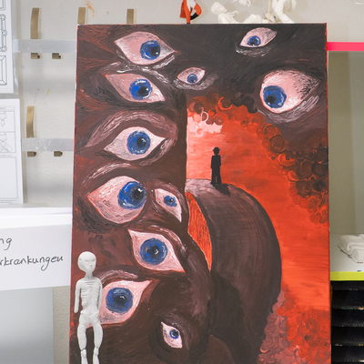 Kunstwerk mit mehreren Augenmotiven auf rotem und dunklem Hintergrund.