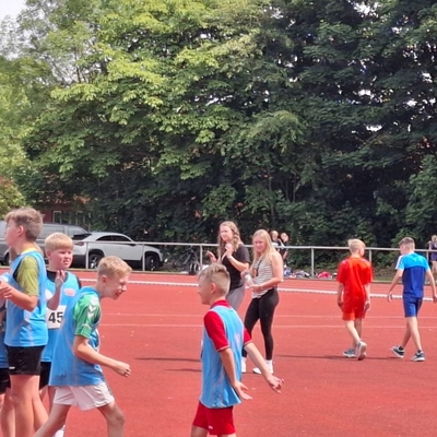 Jugendliche stehen nach einem Wettkampf auf der Laufbahn zusammen.