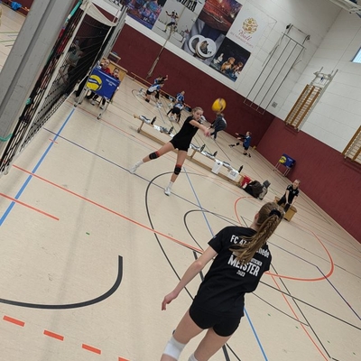 Zwei Volleyballspielerinnen spielen sich gegenseitig den Ball zu.