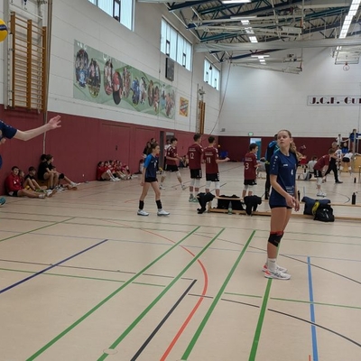 Spielszene aus einem Volleyballspiel in einer Sporthalle.