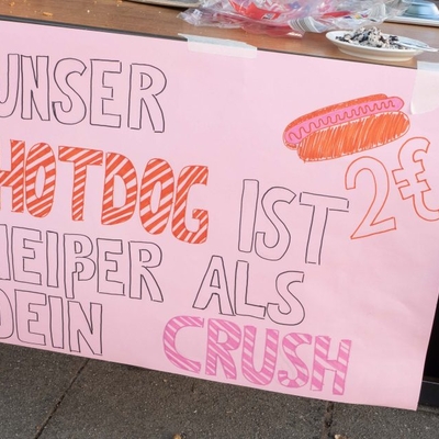 Handgemaltes Schild mit einem Spruch &uuml;ber Hotdogs.