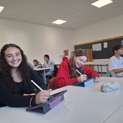 Sch&uuml;lerinnen und Sch&uuml;ler sitzen mit Arbeitsmaterialien im Klassenraum.