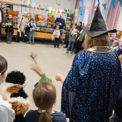 Kinder verfolgen eine Vorf&uuml;hrung mit einer verkleideten Figur bei einer Mitmachstation.