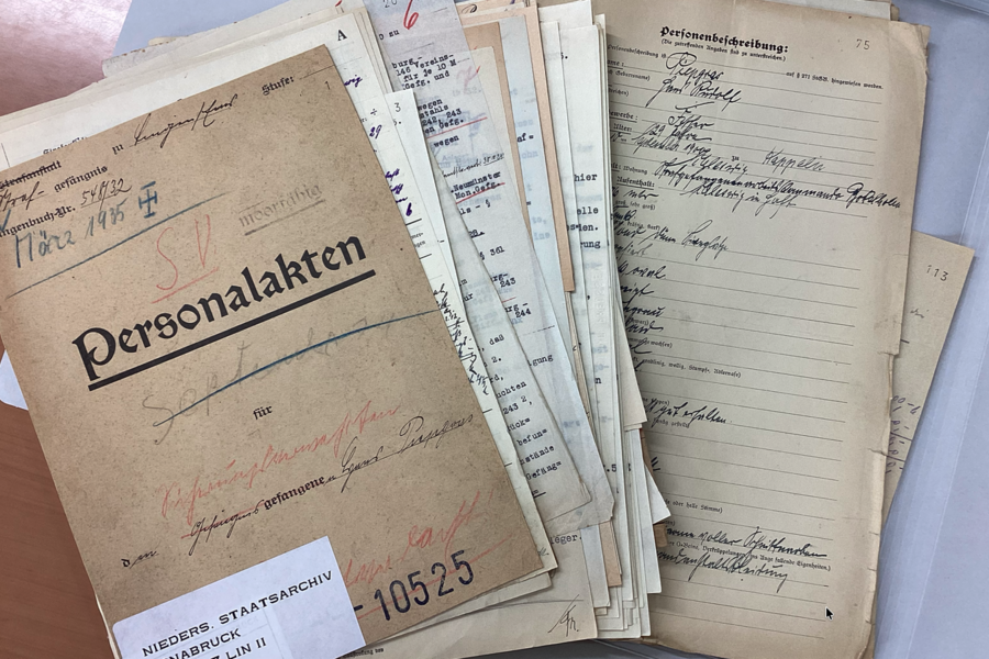 Historische Personalakten und handschriftliche Dokumente aus einem Archiv.
