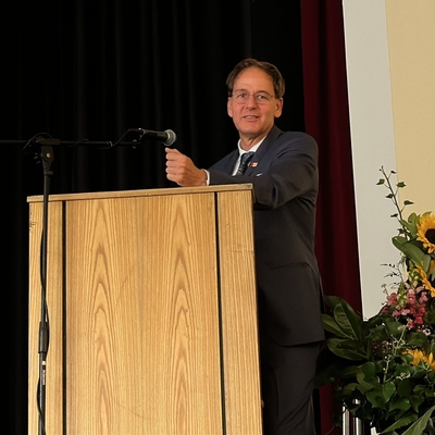 Ein Mann spricht an einem Rednerpult auf einer B&uuml;hne.